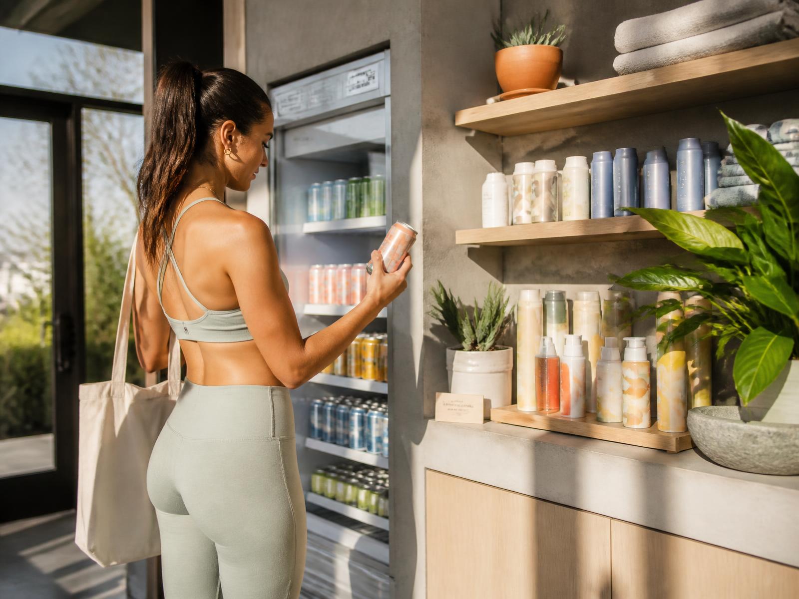 Colorful canned beverages and skincare products displayed in a sunlit modern wellness studio